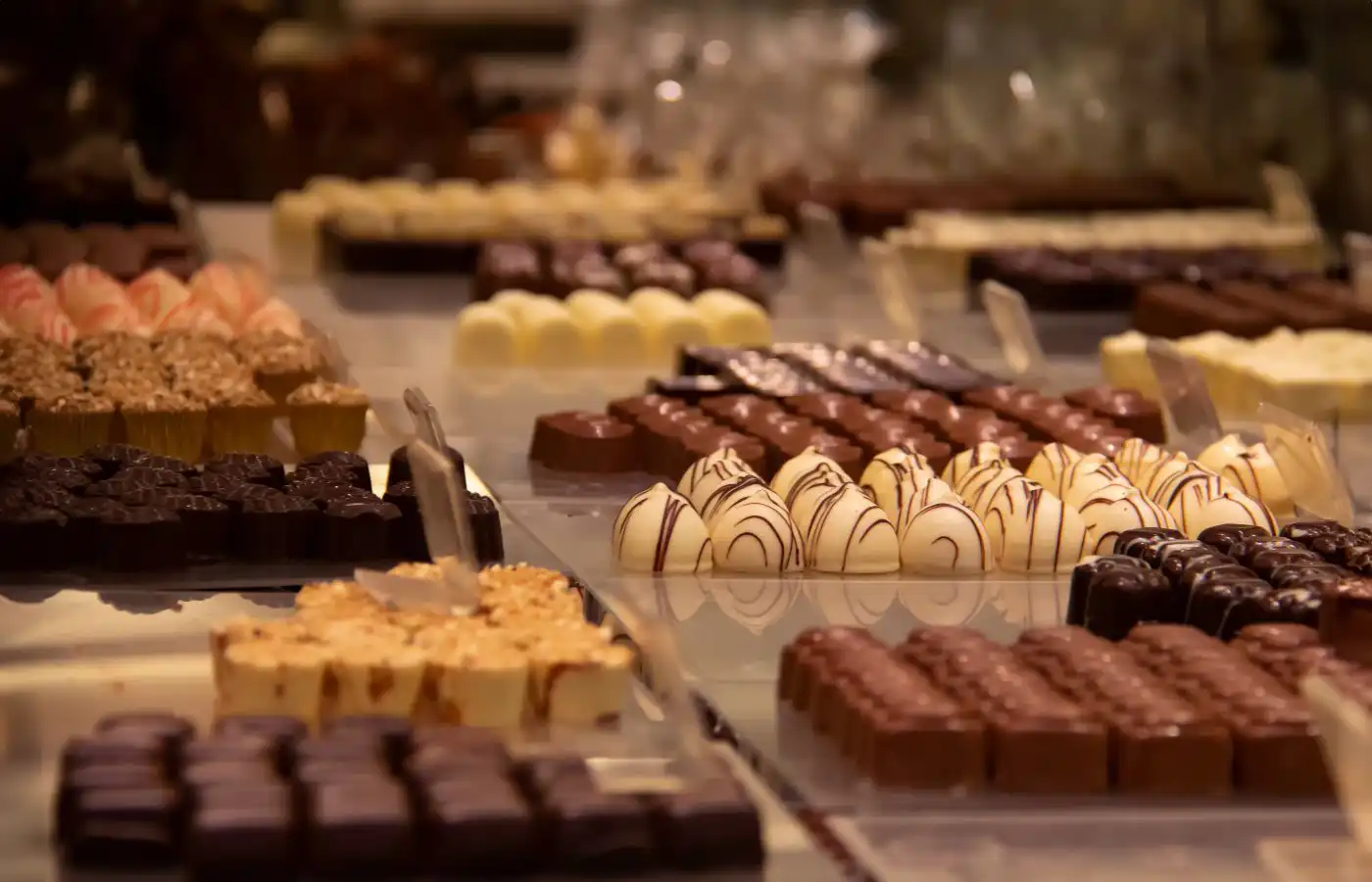 Assortiment van Belgische pralines en chocolade uitgestald in een chocolaterie in Brussel, met een verscheidenheid aan vormen en smaken.